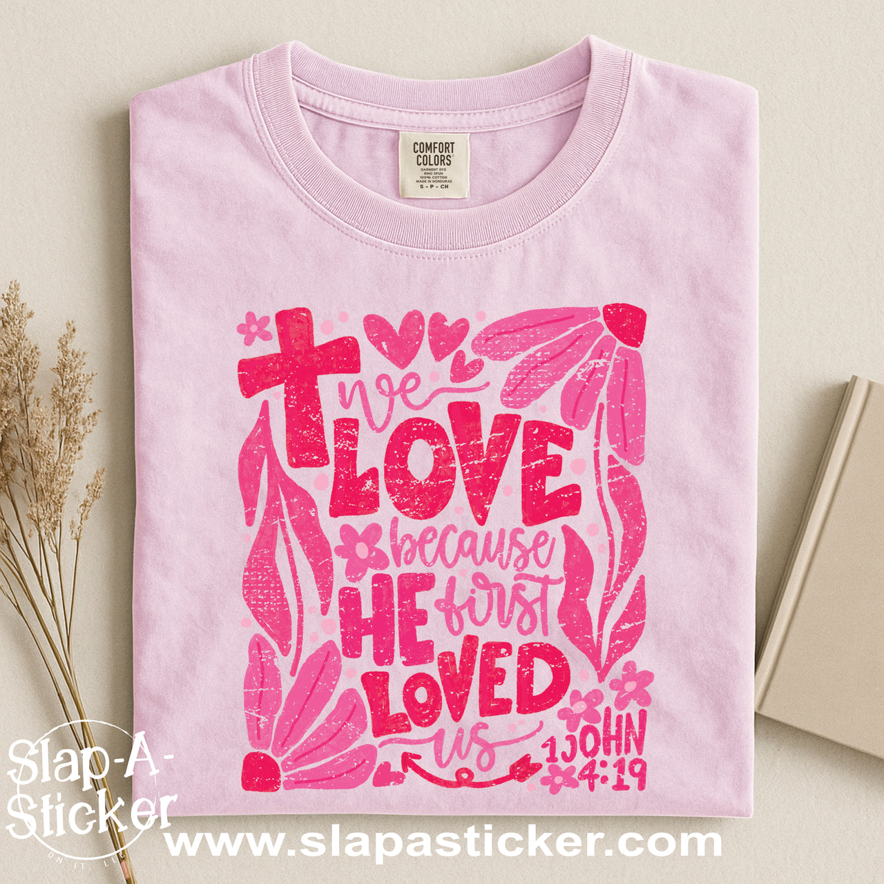 WE LOVE BECAUSE HE FIRST LOVED US - SLAP-A-STICKER ON IT - COMFORT COLORS -  1717 TEE